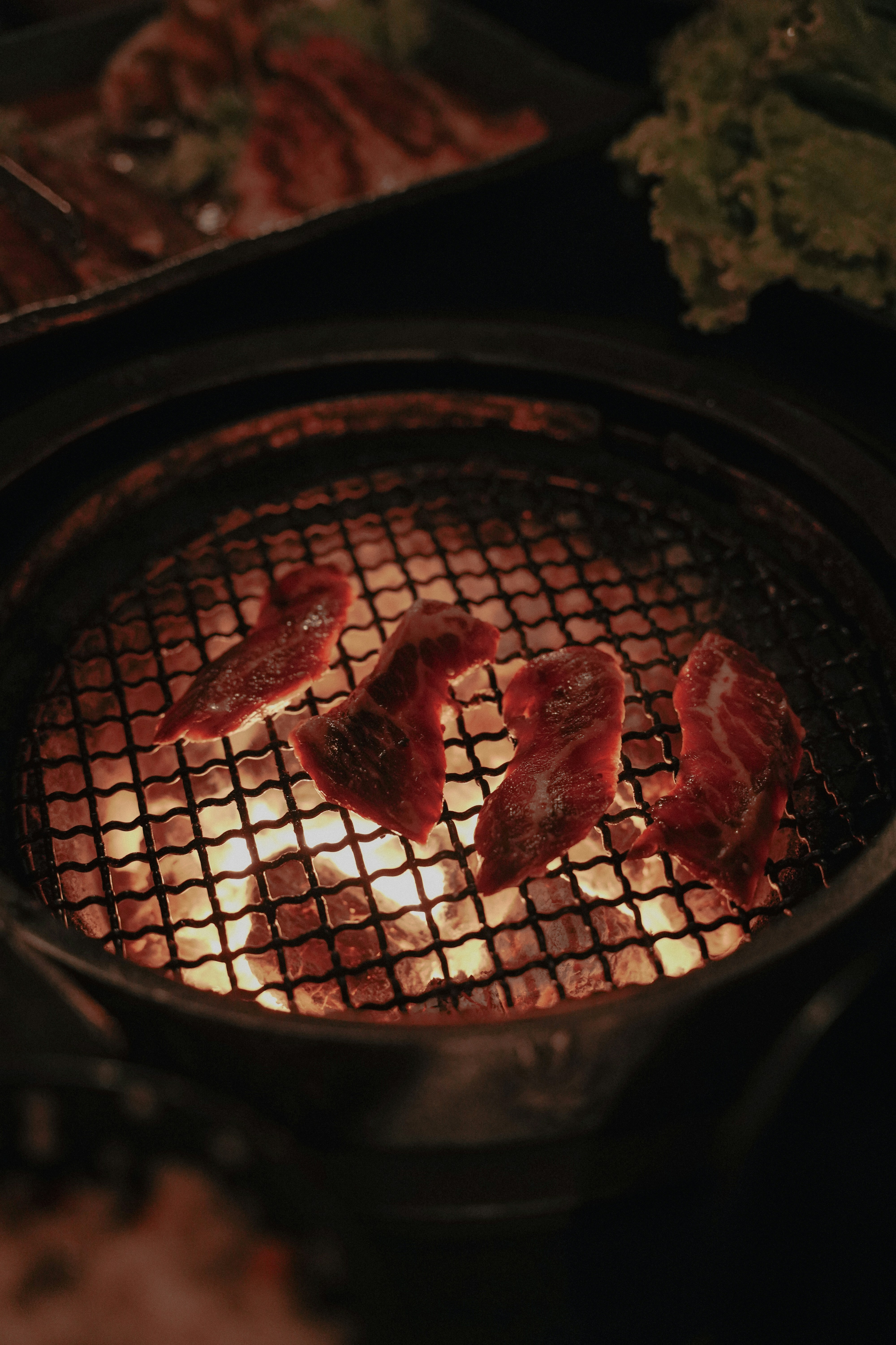 Japanese Wagyu beef grilling over a charcoal fire.